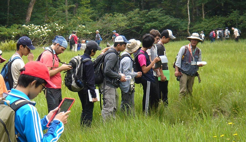 写真：写真は会津高原での合宿から。必携のiPadを使いながら、動植物の観察・研究を行いました