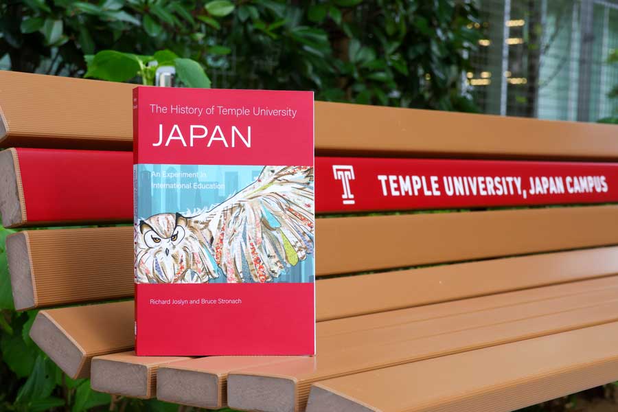 『The History of Temple University Japan: An Experiment of International Education』の書籍。表紙にはTUJのシンボルとなっている学生ラウンジ「パーラメント」の壁画が使われた。壁画は美術学科専攻の卒業生によるもの。 写真撮影：William Galopin